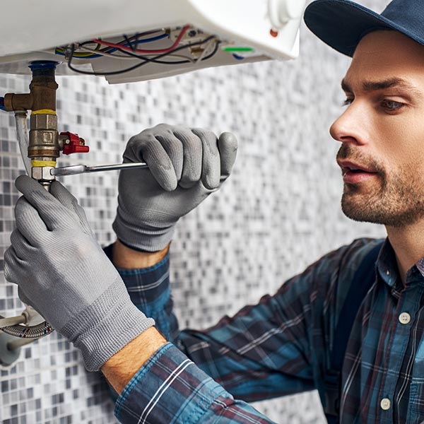 Wrench always with you. Worker set up electric heating boiler at home bathroom